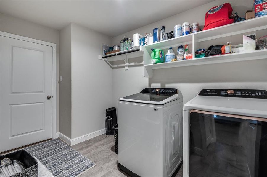 Laundry area featuring washer and clothes dryer and light wood finished floors
