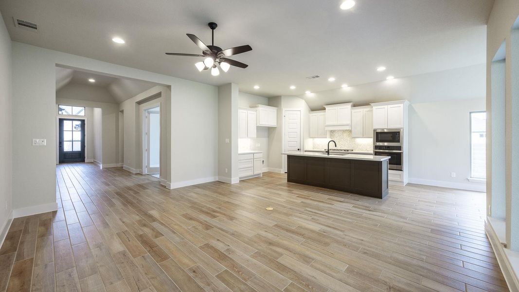 Kitchen with stainless steel oven, a sink, lofted ceiling, built in microwave, and white cabinetry Kitchen with stainless steel oven, a sink, lofted ceiling, built in microwave, and white cabinetry