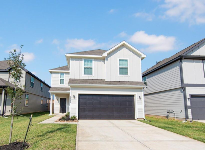 Front exterior of a new home in River's Edge, Conroe, TX, highlighting curb appeal (Image 1).