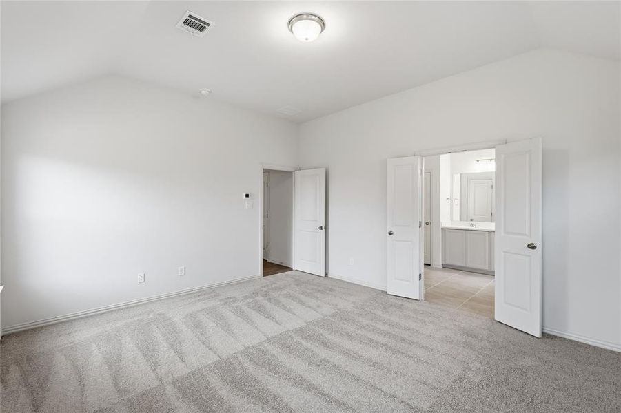 Unfurnished bedroom with light colored carpet and baseboards
