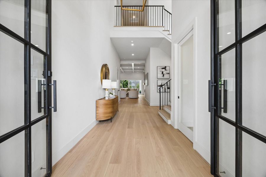 A steel-and-glass front door opens to soaring ceilings, European oak floors, and a bright, elegant entry that sets the tone for the home’s thoughtful design. A steel-and-glass front door opens to soaring ceilings, European oak floors, and a bright, elegant entry that sets the tone for the home’s thoughtful design.