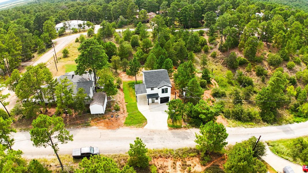 Aerial view of property and surrounding area with a forest Aerial view of property and surrounding area with a forest