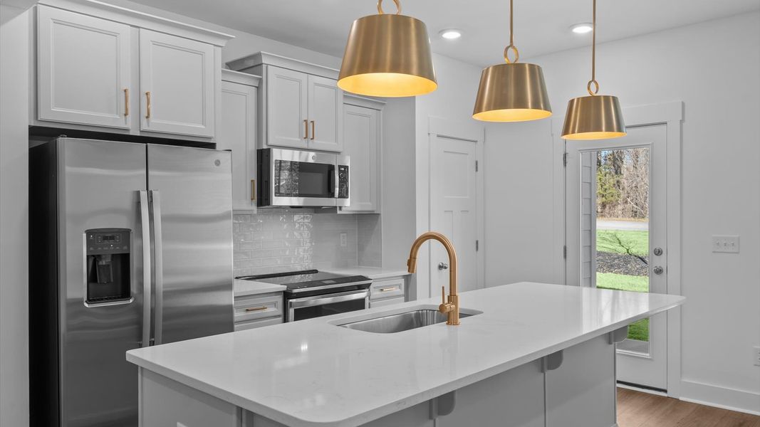 Elegant and compact island anchors this tasteful kitchen with high standards and timeless appeal at Gresham Station