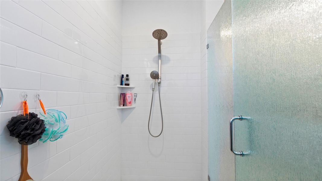 This sleek shower features modern fixtures, crisp white subway tile, and a frosted rain style glass door that provides added privacy while maintaining a clean, contemporary look. This sleek shower features modern fixtures, crisp white subway tile, and a frosted rain style glass door that provides added privacy while maintaining a clean, contemporary look.
