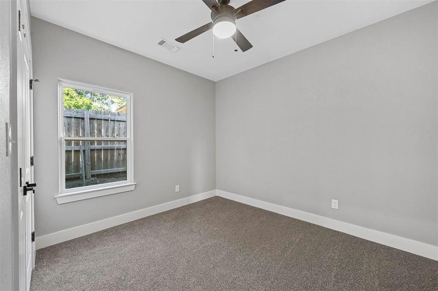 Carpeted spare room featuring ceiling fan