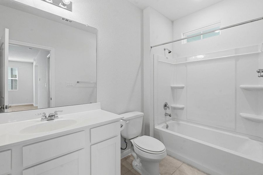 A well-appointed bathroom features a single vanity, a standard toilet, and a combined shower-bathtub unit, all finished in a clean white. A well-appointed bathroom features a single vanity, a standard toilet, and a combined shower-bathtub unit, all finished in a clean white.