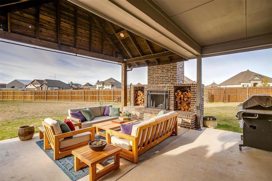 View of patio / terrace featuring an outdoor living space with a fireplace and area for grilling