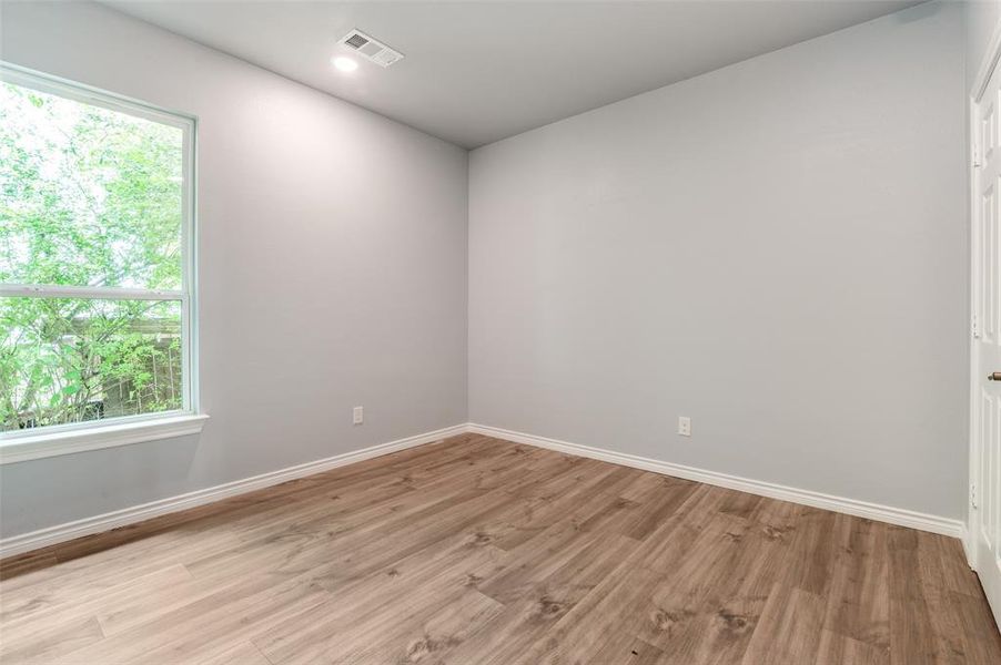 Spare room featuring light hardwood / wood-style floors and plenty of natural light