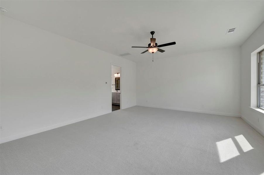 Unfurnished room featuring light carpet and a ceiling fan