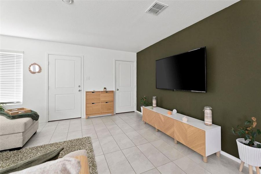 Living area featuring light tile patterned floors and baseboards