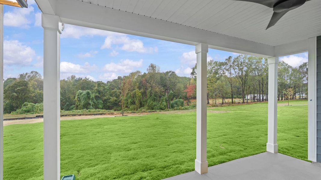 Rear covered porch creates a seamless extension of this home’s elegant design