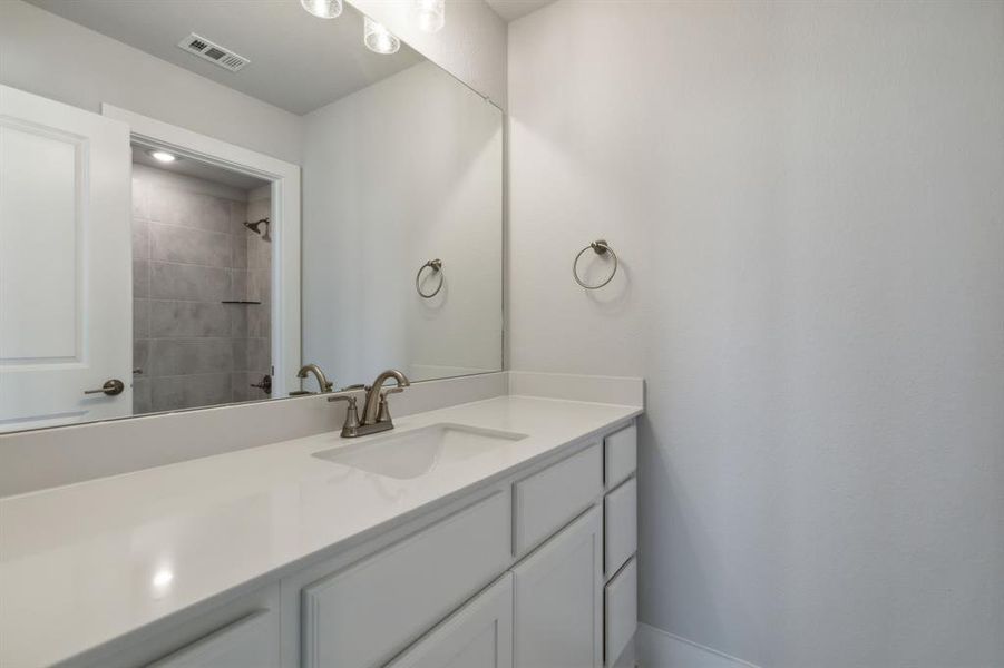 Bathroom with vanity and a tile shower