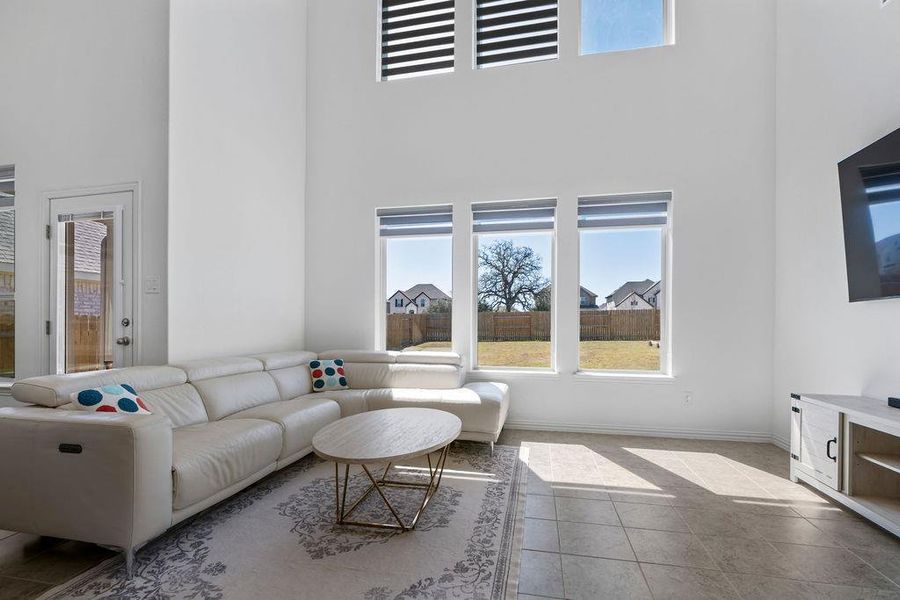 Living room featuring tile patterned flooring and a high ceiling Living room featuring tile patterned flooring and a high ceiling