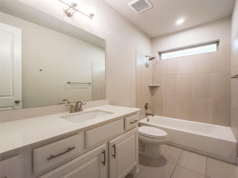 Bathroom featuring shower / bath combination, vanity, and light tile patterned floors Bathroom featuring shower / bath combination, vanity, and light tile patterned floors