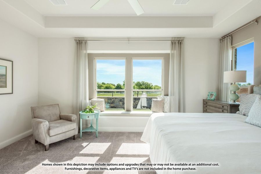 Bright master bedroom with tray ceiling, window seat, and outdoor views