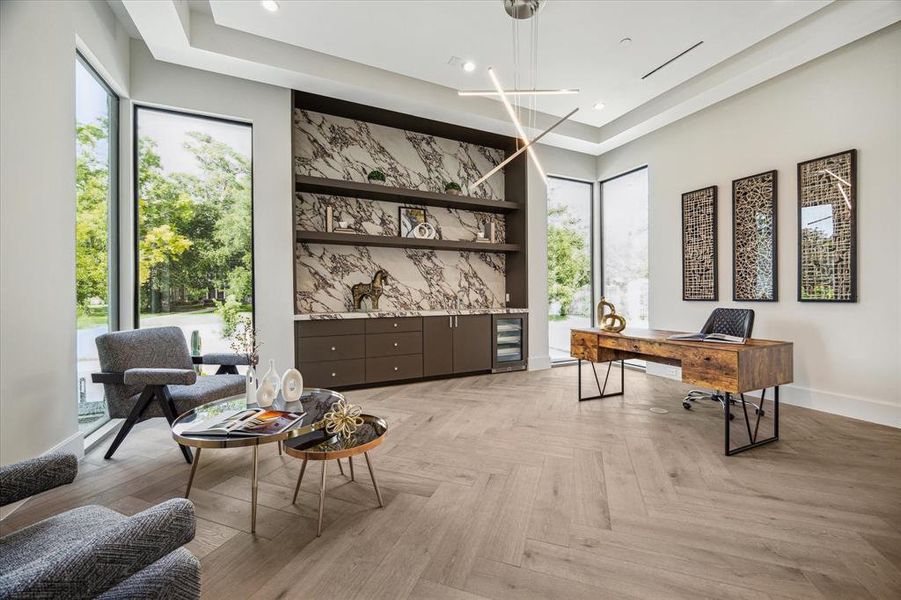 Impeccable design is evident in the first-floor study/office with its double door entry and stained white oak hardwood flooring. The space is bathed in natural light from four windows offeringviews of the front lawn and features StevensWood cabinetry for ample storage. Highlights include a built-in wet bar with a porcelain countertop and full-height backsplash, designer neutral wall paint, in-ceiling speakers, recessed LED lighting, andconvenient access to the second powder room and mudroom.