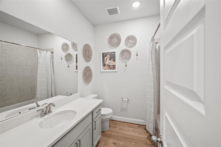Full secondary bath with tub/shower combination and neutral finishes.