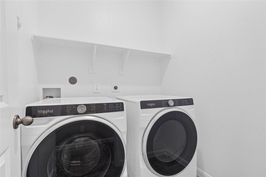 This dedicated laundry room comes equipped with a washer and dryer set, ready for immediate use.