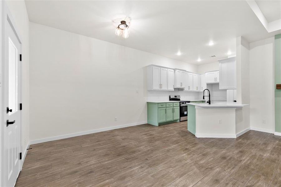 Open-concept kitchen featuring white upper cabinetry, mint green lower cabinetry, and white countertops