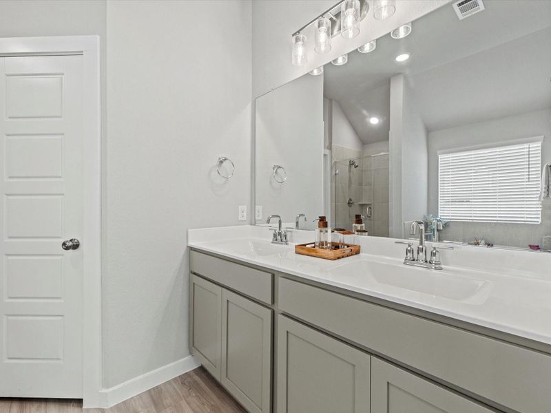 Primary bathroom with dual sinks and oversized vanity.