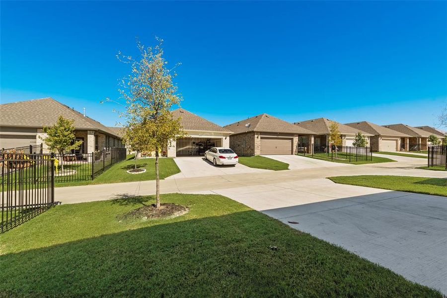 View of backyard with a residential view, driveway, and a garage View of backyard with a residential view, driveway, and a garage