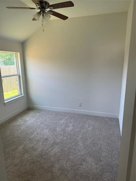 3rd Bedroom with carpet flooring, ceiling fan, and vaulted ceiling