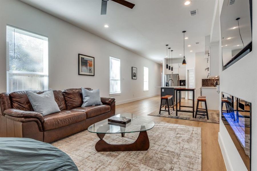 Living room featuring light hardwood / wood-style floors, a wealth of natural light, and ceiling fan