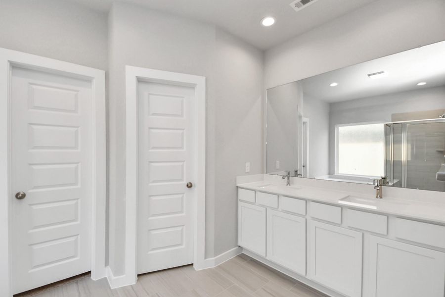 Elevate your daily routine at the elegant vanity, now equipped with double sinks, light countertops, modern hardware, and beautiful recessed lights. Sample photo of completed home with similar floor plan. Actual colors and selections may vary. Elevate your daily routine at the elegant vanity, now equipped with double sinks, light countertops, modern hardware, and beautiful recessed lights. Sample photo of completed home with similar floor plan. Actual colors and selections may vary.