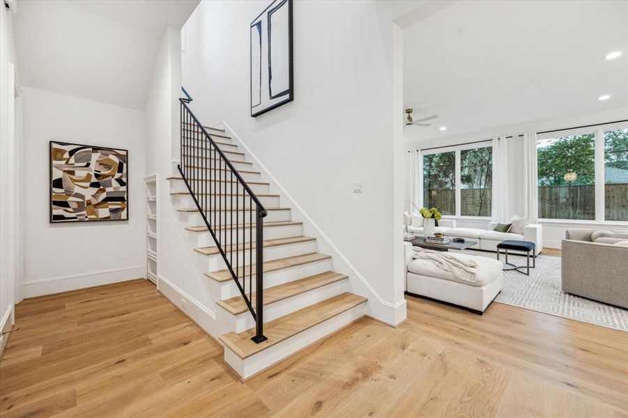 The staircase to the second floor features a custom black railing and a hidden gem—a secret  door w/ shelving that opens to a spacious under-stair storage room. Perfect for stashing essentials, toys, or creating a cozy nook for your dog or little ones!