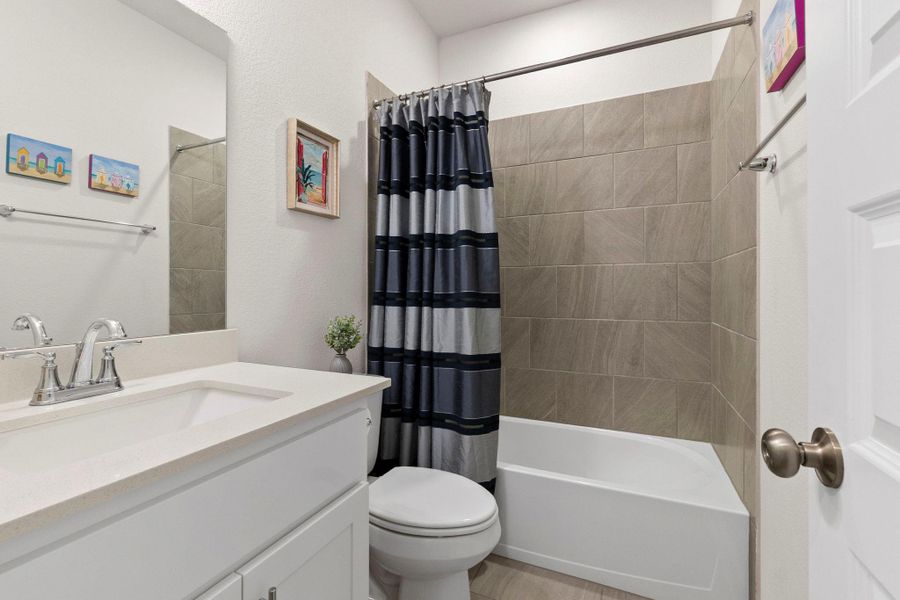 Bathroom featuring a white vanity with a light-toned countertop, an undermount sink, and a chrome faucet