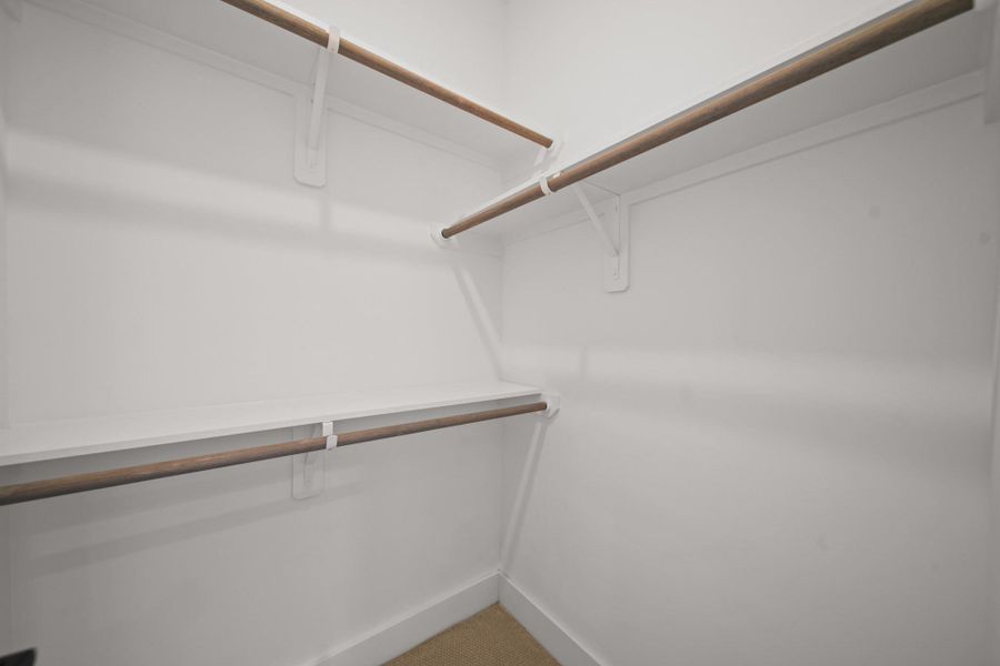 The bedroom closet includes built-in shelves and hanging rods, offering ample space to store clothing and essentials. The bedroom closet includes built-in shelves and hanging rods, offering ample space to store clothing and essentials.