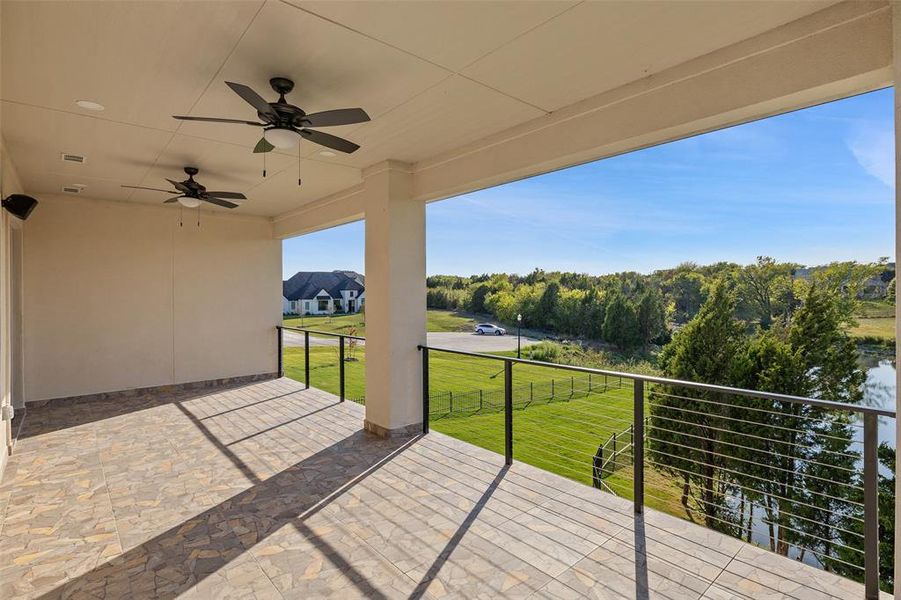 View of patio with ceiling fan and a balcony