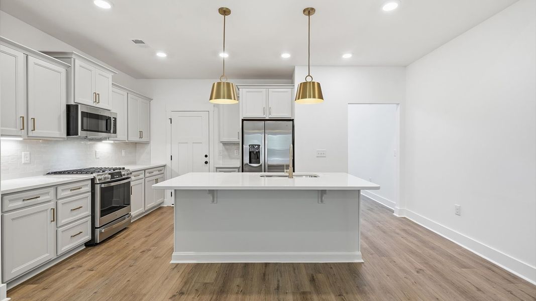 Elegant and compact island anchors this tasteful kitchen with high standards and timeless appeal by DRB Homes Elegant and compact island anchors this tasteful kitchen with high standards and timeless appeal by DRB Homes