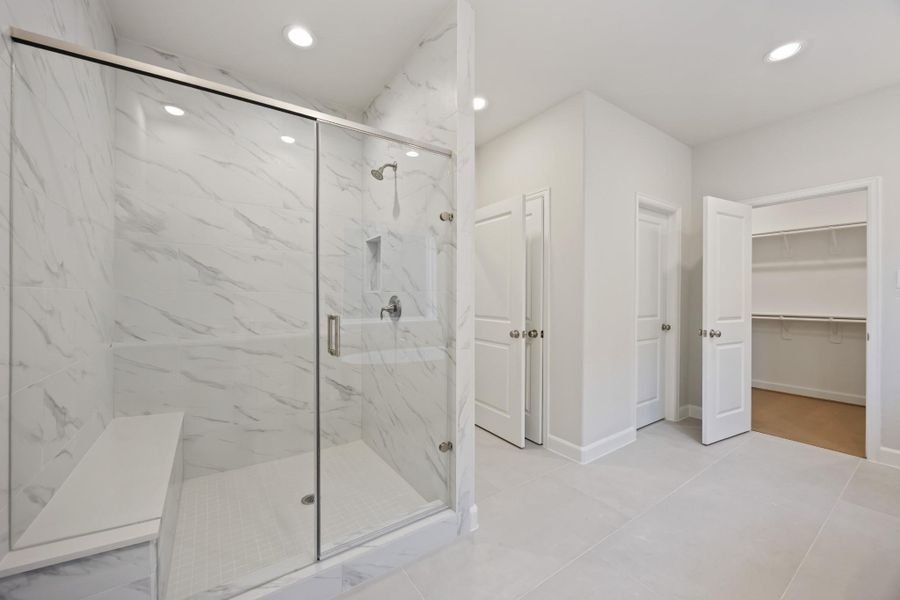 A large, step-in shower with bench seating and a separate water closet redefine luxury, making every morning a spa-like experience. A large, step-in shower with bench seating and a separate water closet redefine luxury, making every morning a spa-like experience.