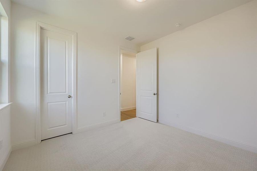 Unfurnished bedroom with carpet flooring and baseboards