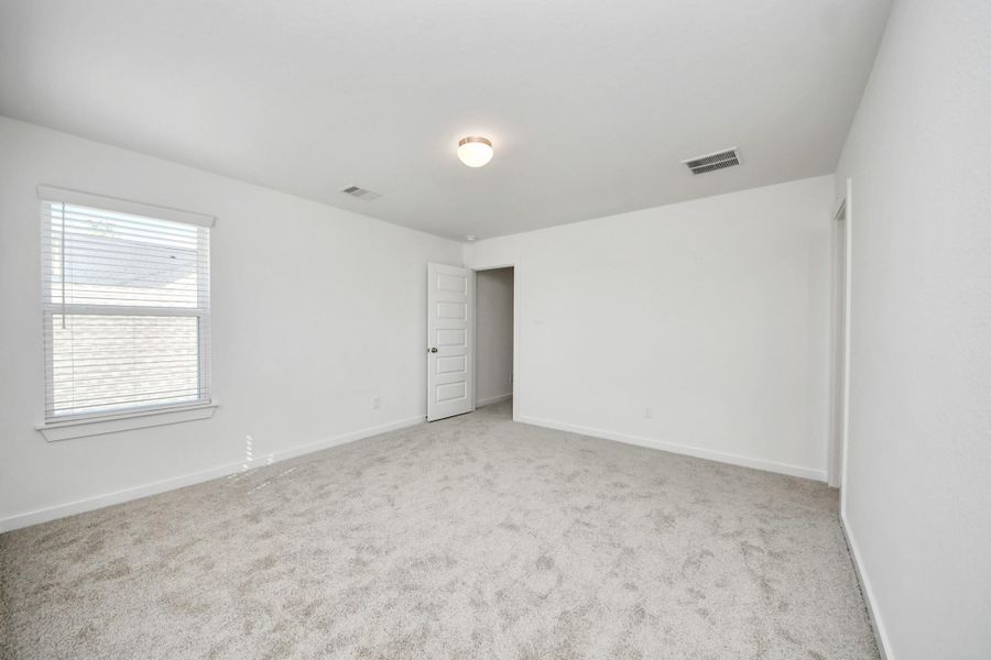 Generously sized secondary bedrooms featuring spacious closets, soft and inviting carpeting underfoot, large windows allowing plenty of natural light, and the added touch of privacy blinds for your personal retreat. Sample photo of completed home with similar floor plan. Actual colors and selections may vary.