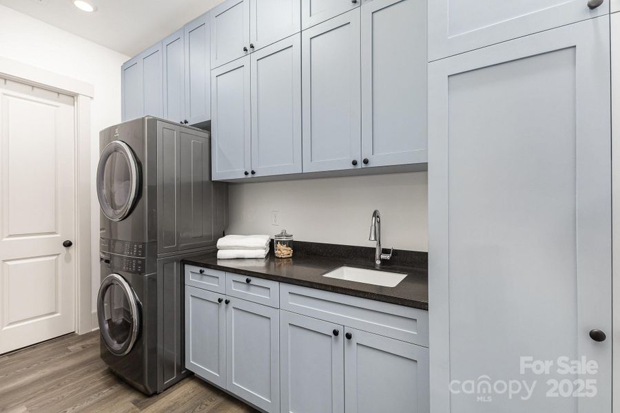 Large laundry room with tons of cabinet space for storage, a sink and plenty of counter space. Easy access from the primary suite Large laundry room with tons of cabinet space for storage, a sink and plenty of counter space. Easy access from the primary suite