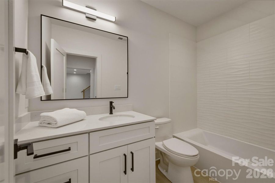 This third bathroom features an acrylic tub with custom tiled walls. This third bathroom features an acrylic tub with custom tiled walls.