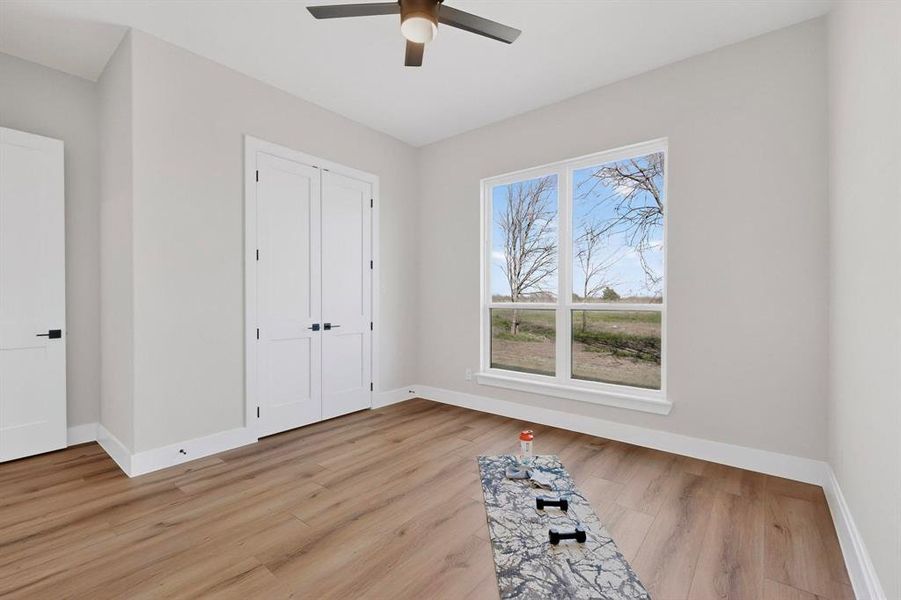 Unfurnished bedroom featuring ceiling fan, light wood-style floors, and a closet