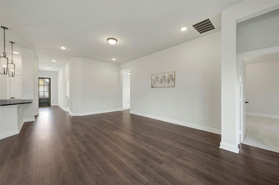 Unfurnished living room featuring dark wood-style floors and recessed lighting