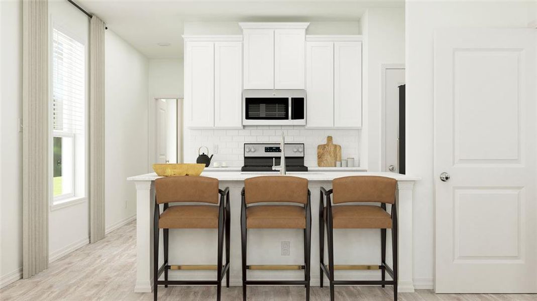 Kitchen with light wood-type flooring, white cabinets, backsplash, appliances with stainless steel finishes, and a kitchen breakfast bar