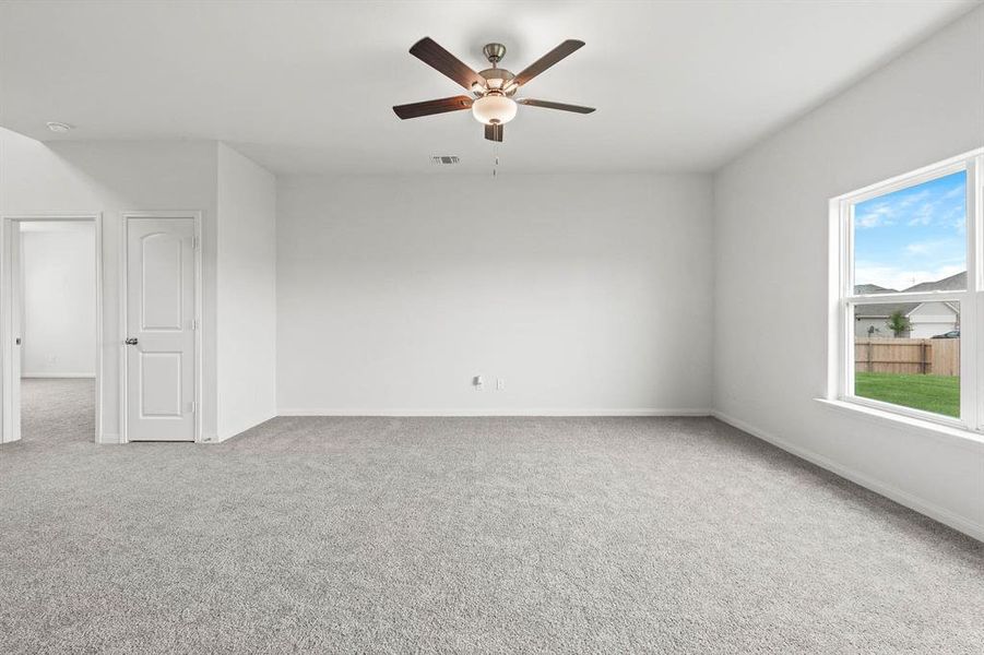 Carpeted spare room featuring ceiling fan