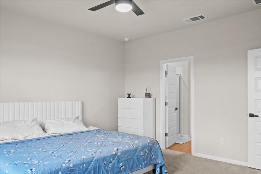 Bedroom featuring carpet floors, ceiling fan, and connected bathroom