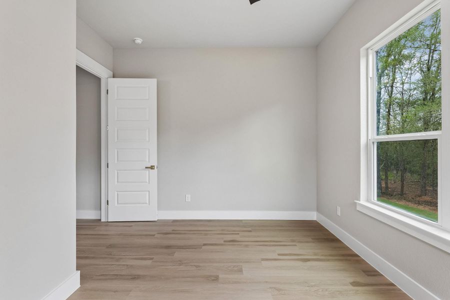 A quiet bedroom featuring resilient flooring and views of surrounding natural landscapes.