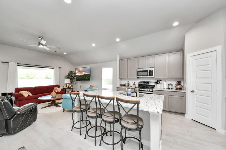 A central prep island doubles as a casual breakfast bar, anchoring the heart of the home with clean sightlines into the living space.