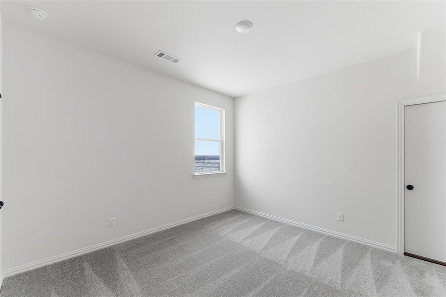 Empty room featuring carpet and baseboards