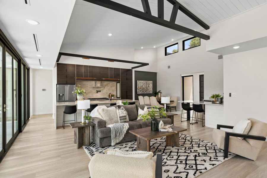 Living area featuring light wood-style flooring, recessed lighting, and lofted ceiling