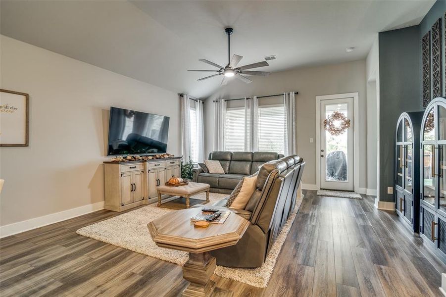 Living room featuring vaulted ceiling, dark hardwood / wood-style floors, and ceiling fan