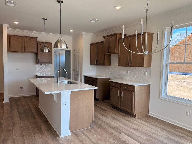 Beautiful Kitchen with decorative light fixtures, island & quartz counter tops.