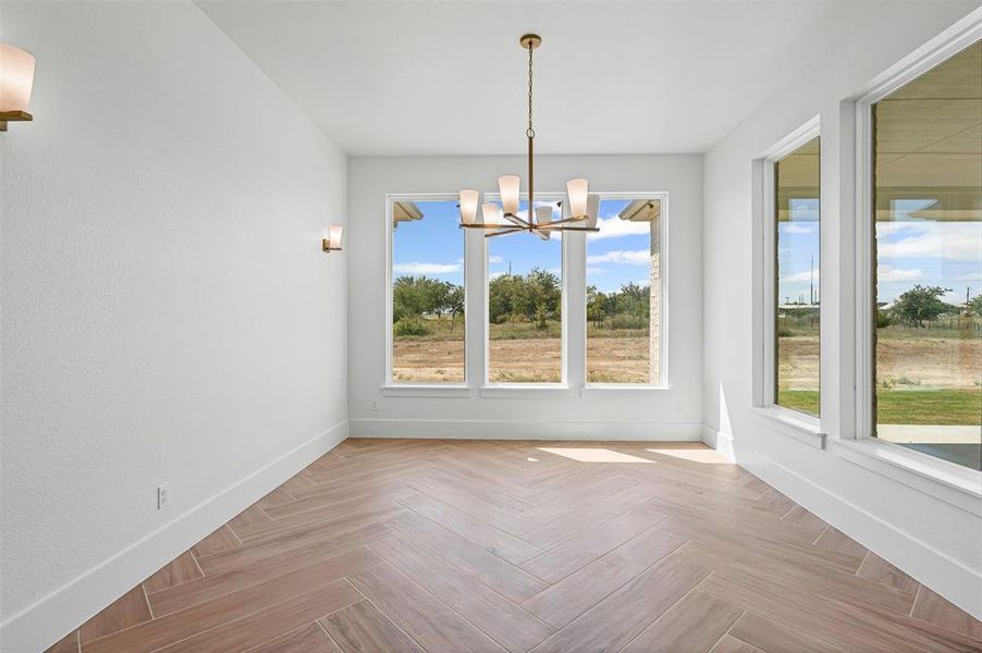 Unfurnished dining area with baseboards and a chandelier Unfurnished dining area with baseboards and a chandelier